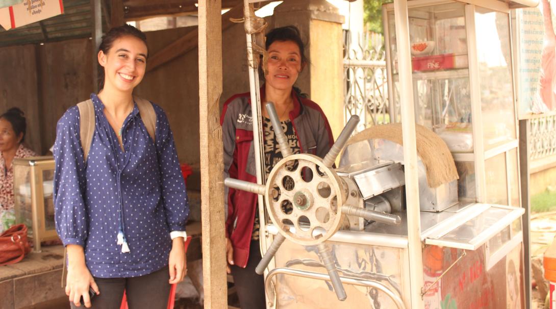 High School Special volunteer take a photo with a local entrepreneur by her beverage stand in Cambodia. Projects Abroad volunteer visits a beneficiary who sells beverages in Cambodia.